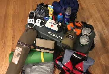 Hiking boots, sunscreen bottle, toothpaste, whistle, first aid kit, goggles, compass, mess kit, toothbrush, hammock, lanterns, sleeping bag, foot powder bottle, flip flops, nylon book cover, camp chair, sleeping pad, tarp, life preserver, foot locker.